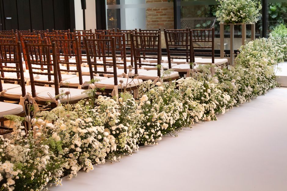 Pasillo de una ceremonia decorado con flores blancas